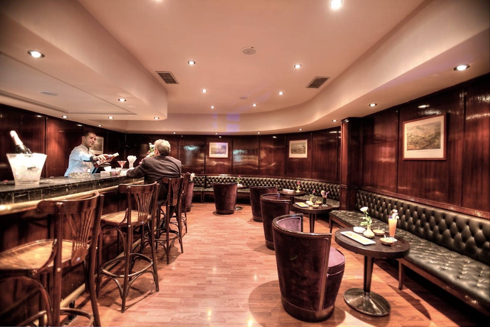 Le bar en boiseries, tabourets et banquettes