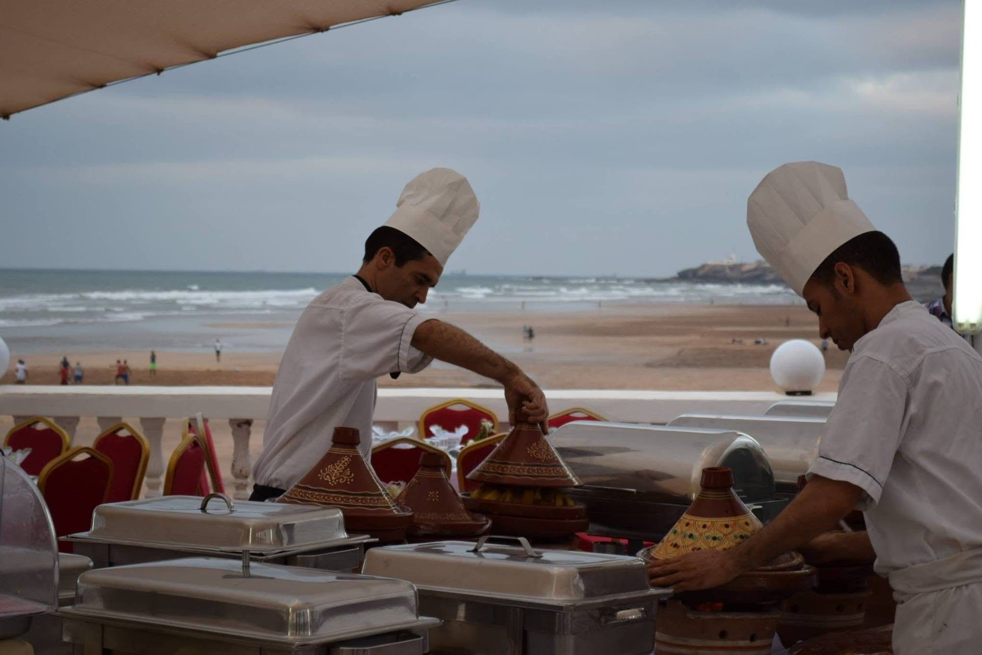 Des chefs aux grillades sur la terrasse face à la plage