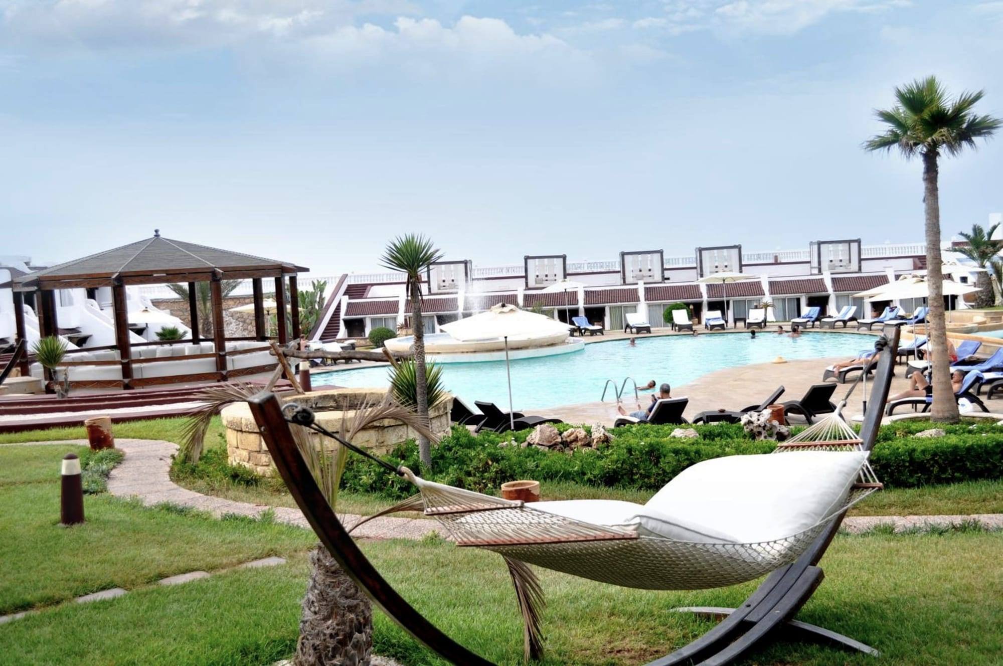 Hamac au jardin, la piscine et le kiosque en bois derrière