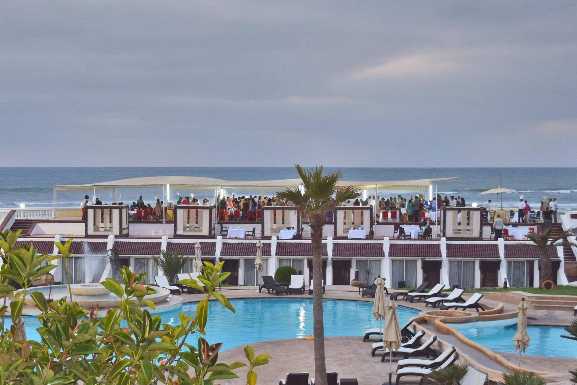 Le soir sur la terrasse au-dessus de la plage, la piscine au premier plan
