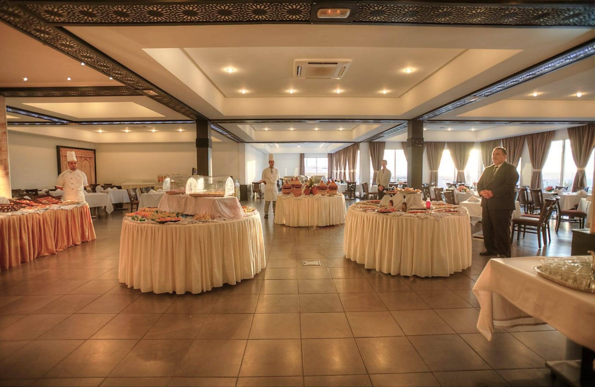 Salle des buffets, tables rondes et chef derrière le buffet